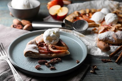 Photo of Delicious apple galette with ice cream and pecans on wooden table