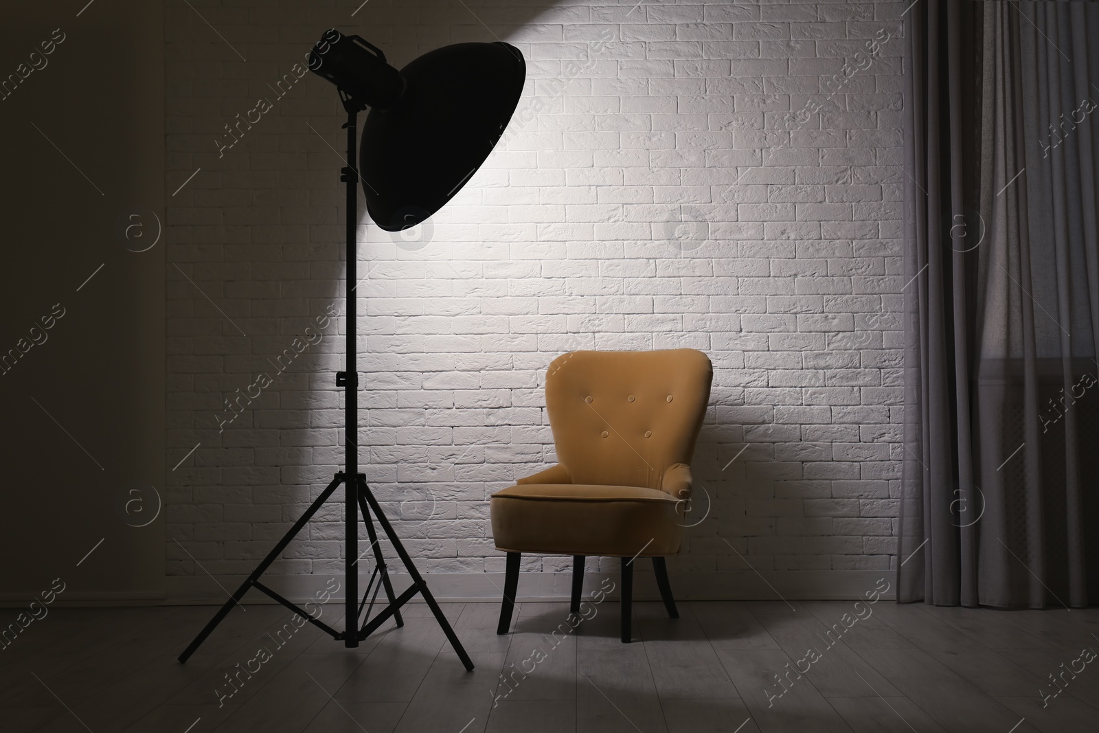 Photo of Interior of modern photo studio with professional lighting equipment and armchair