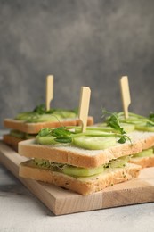 Photo of Tasty sandwiches with cucumber and microgreens on textured table