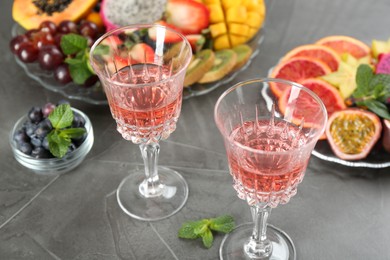 Photo of Delicious exotic fruits and wine on grey table