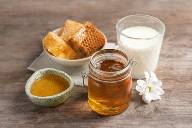 Photo of Beautiful composition with milk and honey on wooden background