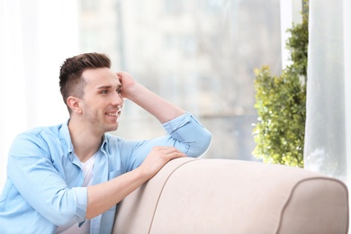 Photo of Young man resting on sofa at home