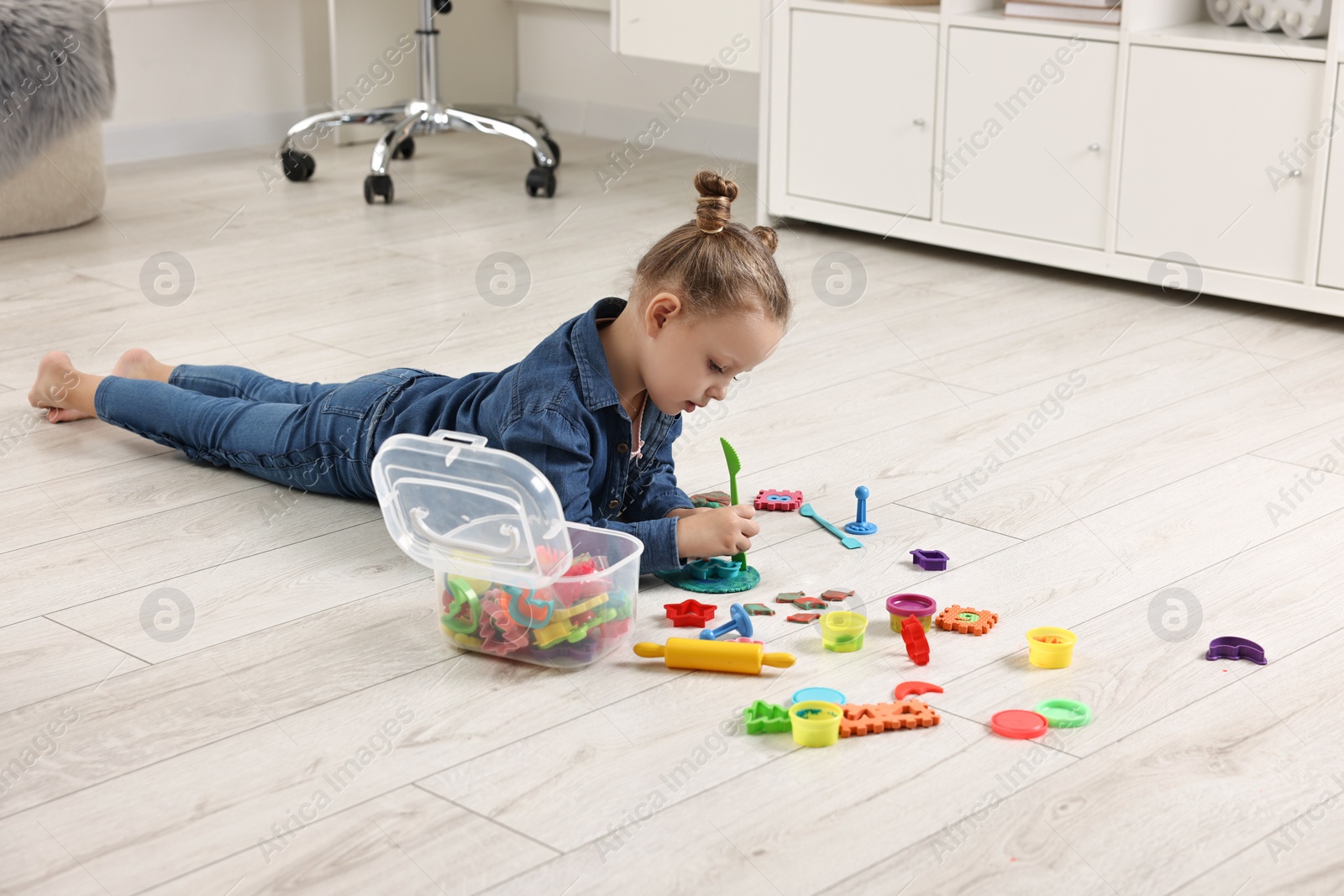 Photo of Cute little girl playing on warm floor at home. Heating system