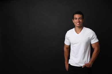 Photo of Handsome young African-American man on black background. Space for text