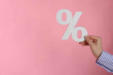 Photo of Woman holding percent sign on pink background, closeup. Space for text