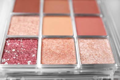 Photo of Beautiful eyeshadow palette as background, closeup. Professional cosmetic product