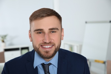 Photo of Portrait of young businessman laughing at workplace