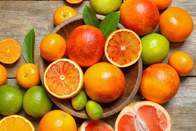 Photo of Flat lay composition with different citrus fruits on wooden background