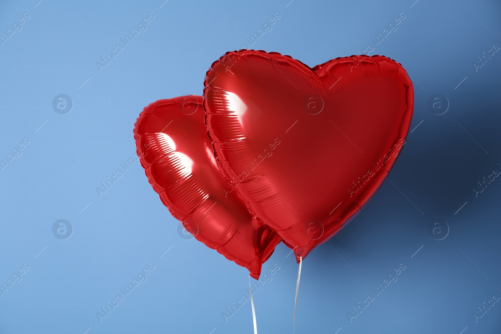 Photo of Red heart shaped balloons on blue background. Valentine's Day celebration