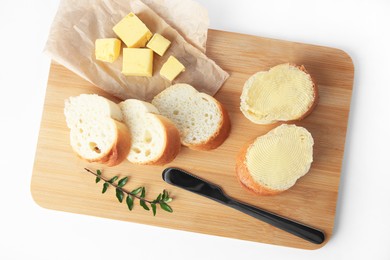 Photo of Wooden board with sliced baguette and fresh butter on white background, top view