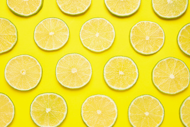 Photo of Fresh juicy lime slices on yellow background, flat lay