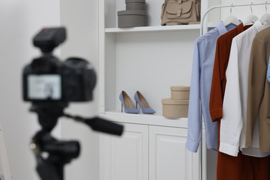 Fashion blogger's workplace. Shoes, clothes, camera and stylish furniture indoors