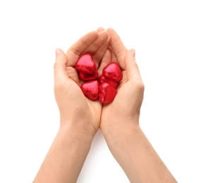 Photo of Woman holding heart shaped chocolate candies on white background, closeup