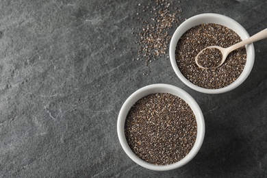 Photo of Bowls with chia seeds on grey background, flat lay. Space for text