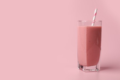 Photo of Glass with delicious berry smoothie on pink background. Space for text
