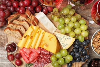 Photo of Flat lay composition with wine and snacks on wooden background