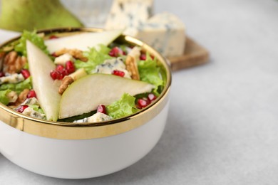 Photo of Delicious pear salad in bowl on light table, closeup. Space for text