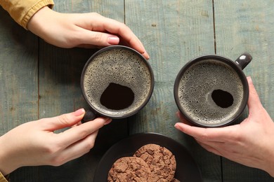 Photo of Women having coffee break at rustic wooden table, top view