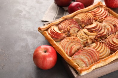 Photo of Tasty apple pie and fresh fruits on grey table, space for text