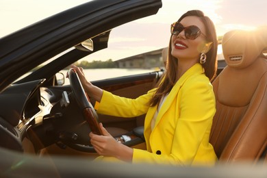 Photo of Beautiful businesswoman in luxury convertible car outdoors
