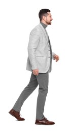 Photo of Handsome bearded businessman walking on white background