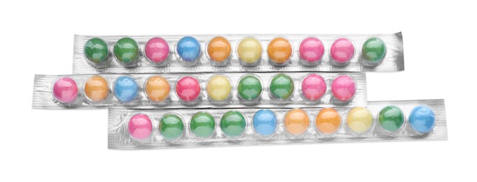 Photo of Packages with many bright gumballs isolated on white, top view