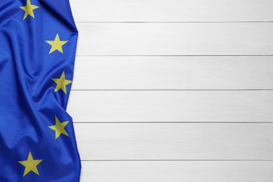 Photo of Flag of European Union on white wooden background, top view. Space for text
