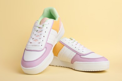 Photo of Pair of comfortable sports shoes on beige background