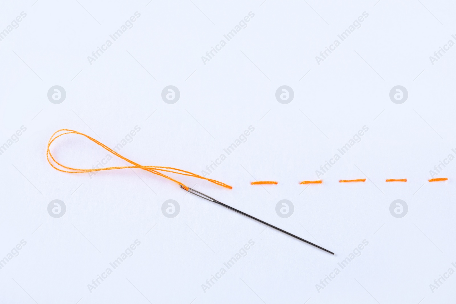 Photo of Yellow embroidery and needle on white background