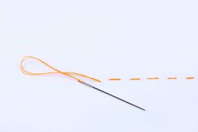 Photo of Yellow embroidery and needle on white background