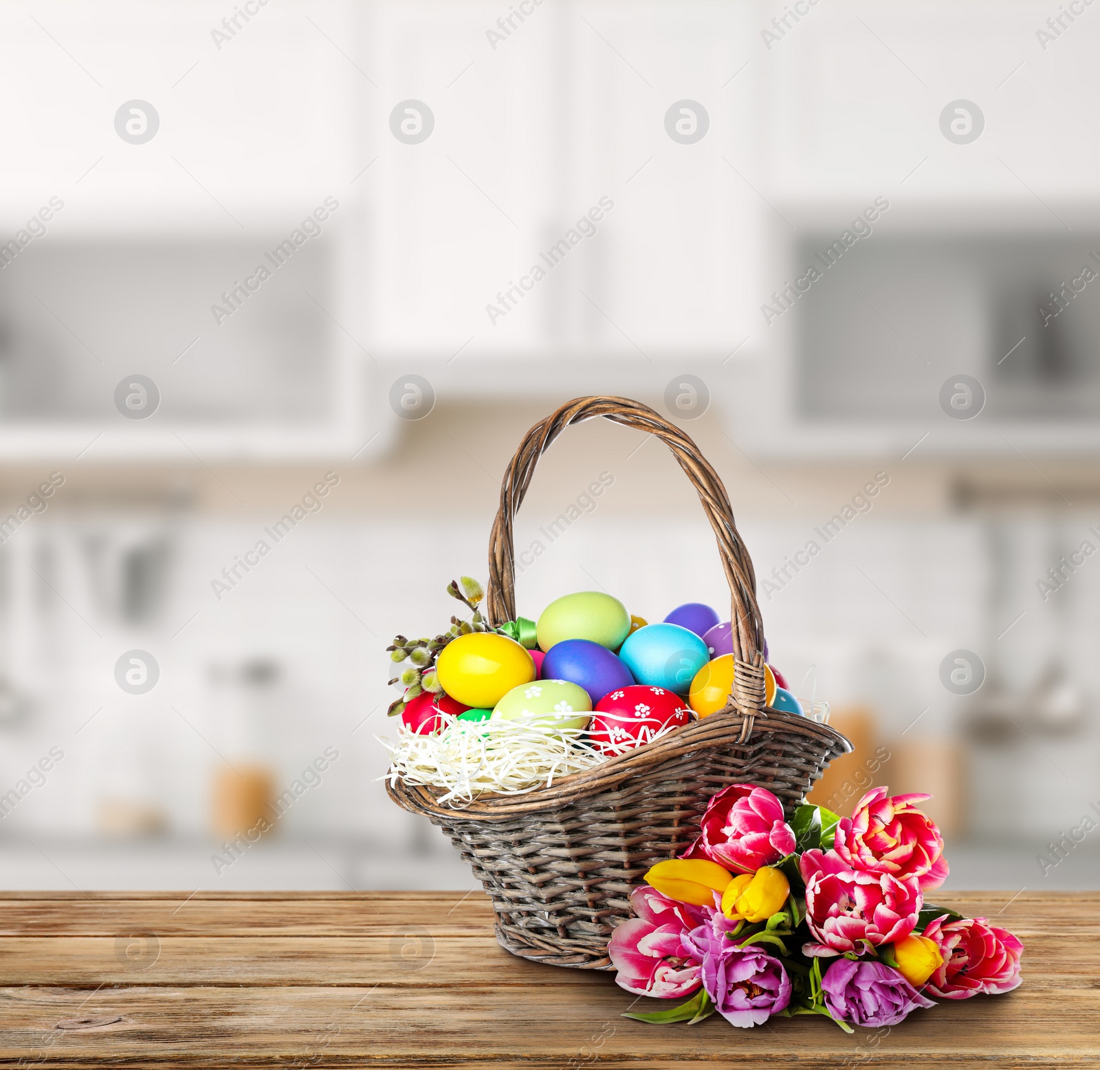 Image of Wicker basket with bright painted Easter eggs on wooden table indoors