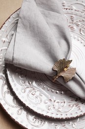 Photo of Fabric napkin and decorative ring for table setting on plate, top view