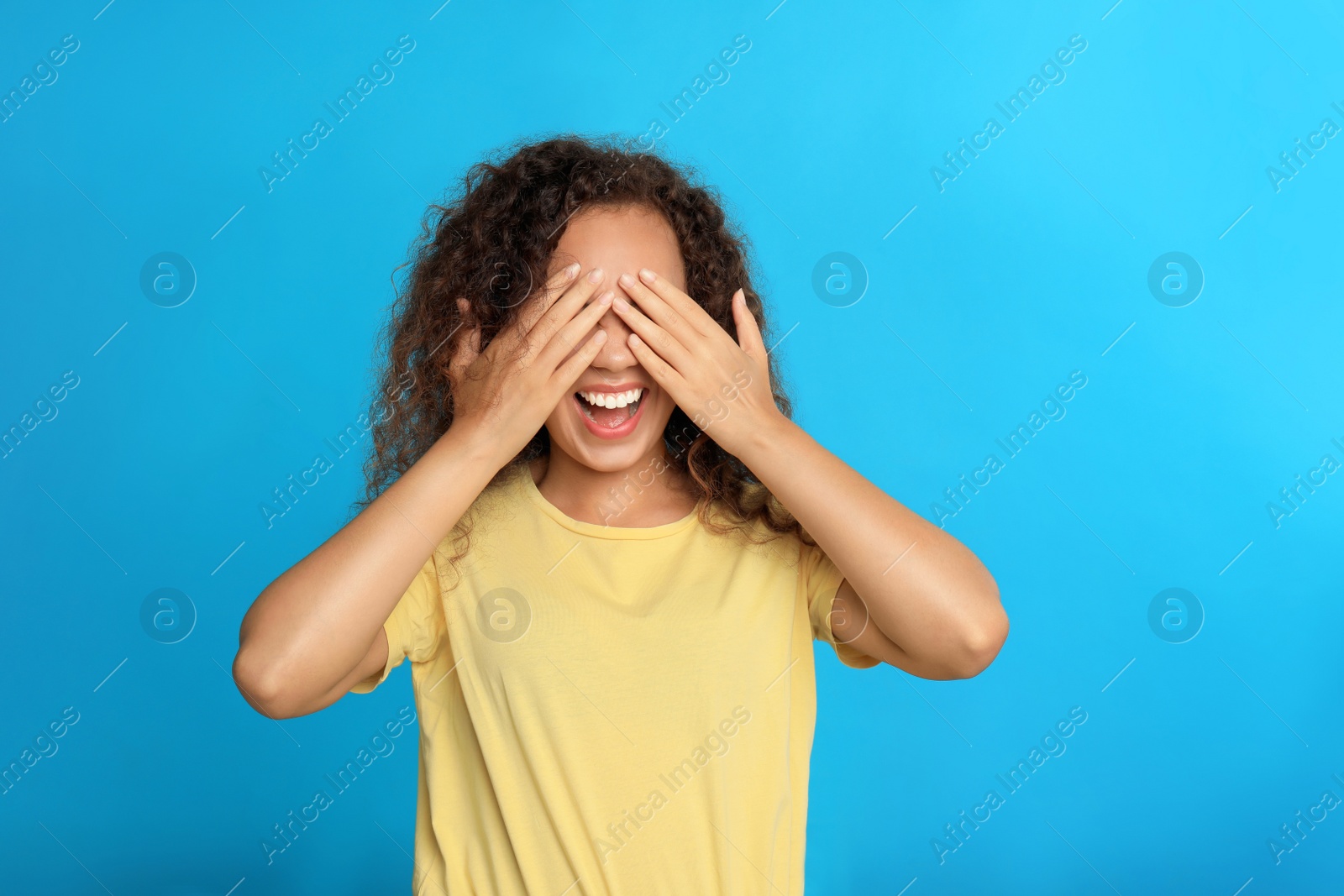 Photo of Young African-American woman being blinded on blue background