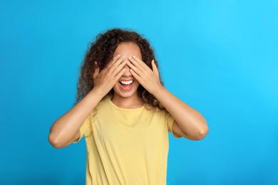 Young African-American woman being blinded on blue background