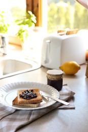 Photo of Tasty toasts with jam on countertop in kitchen, space for text