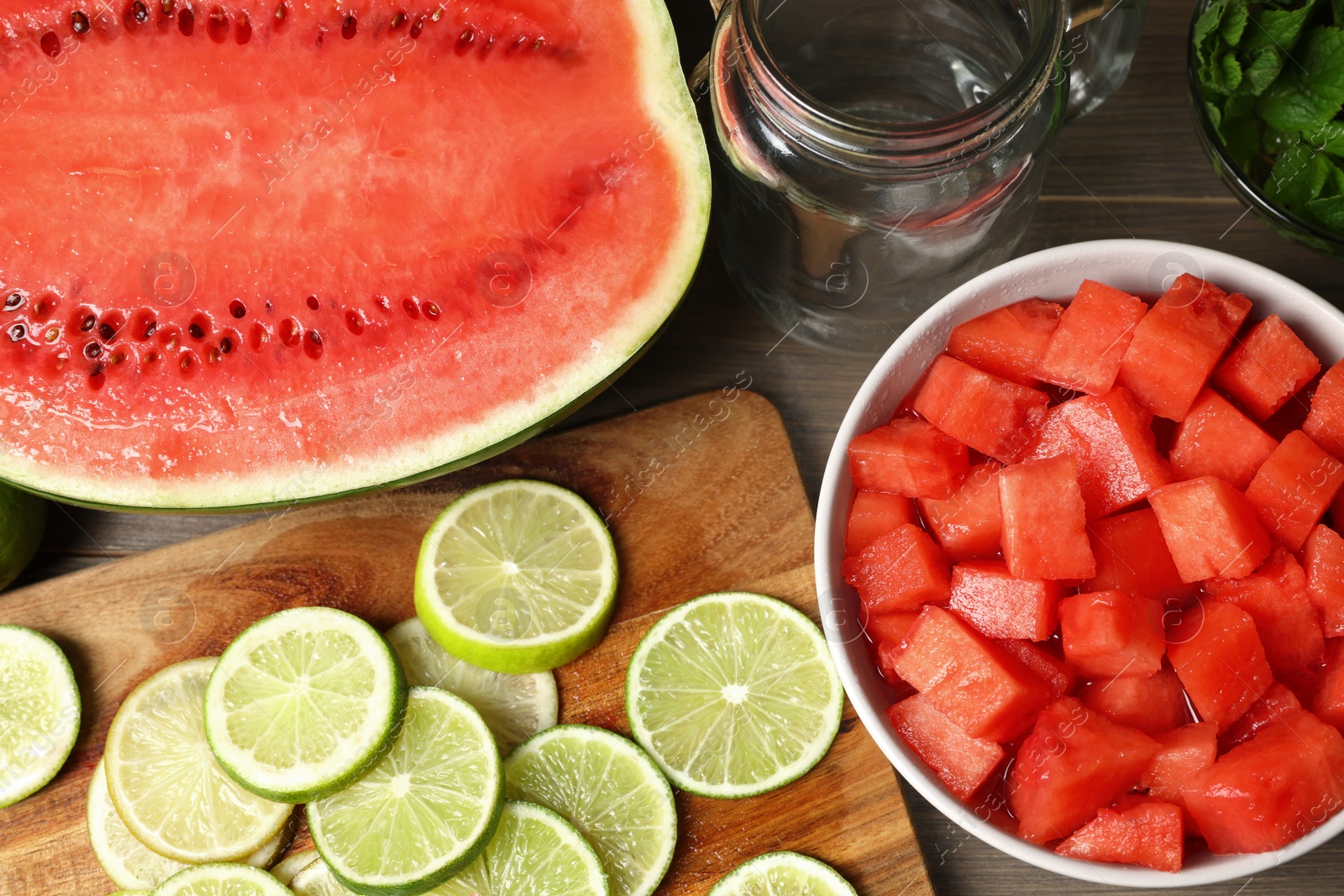 Photo of Fresh ingredients for making watermelon drink with lime on wooden table, above view