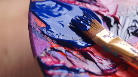 Photo of Artist's palette with mixed paints and brush, closeup