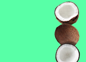 Image of Stack of fresh coconuts on light green background. Space for text
