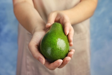 Woman holding ripe fresh avocado, closeup