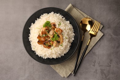 Delicious rice with parsley and mushrooms served on grey table, flat lay