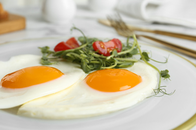 Photo of Tasty fried eggs with tomato and sprouts on plate, closeup