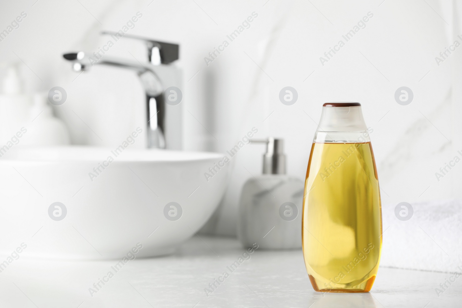 Photo of Bottle of shampoo near sink on bathroom counter, space for text