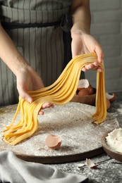 Photo of Woman making homemade pasta at table, closeup