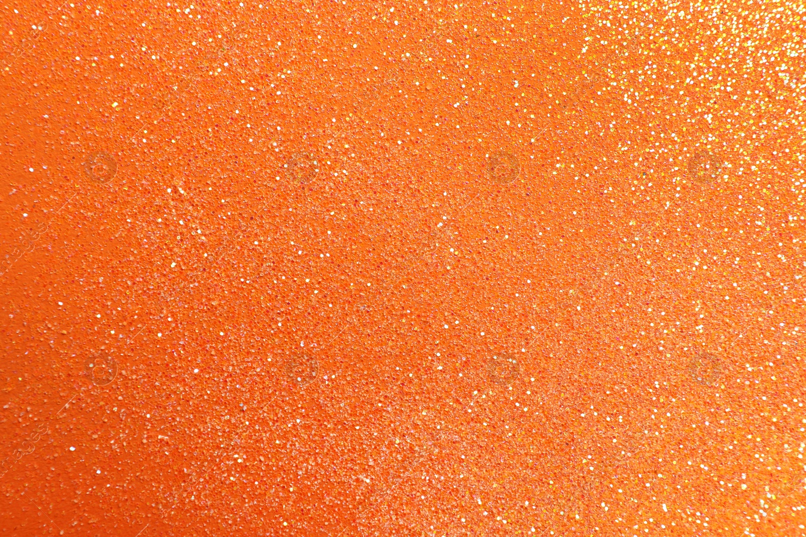 Photo of Shiny bright glitter on orange background, flat lay