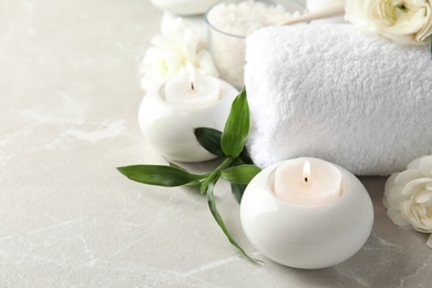 Photo of Beautiful spa composition with candles and flowers on marble background, space for text