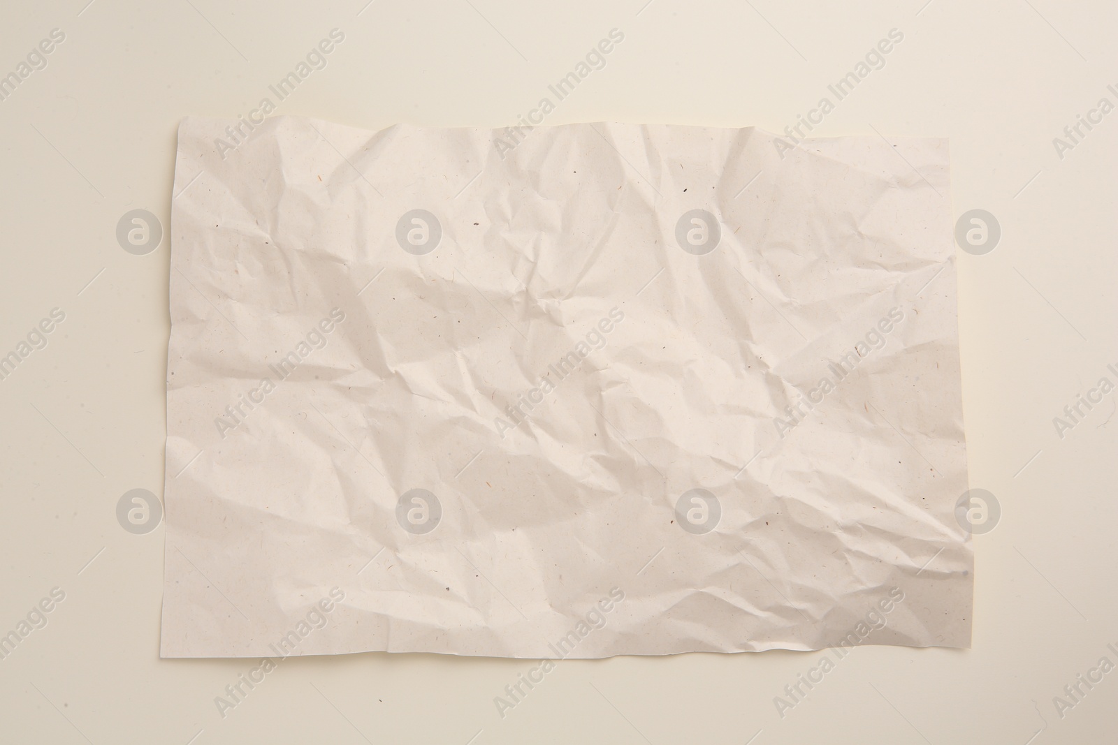 Photo of Sheet of crumpled parchment paper on beige background, top view