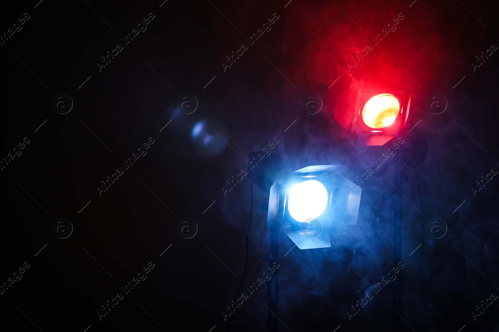 Photo of Bright colorful spotlights in darkness, space for text