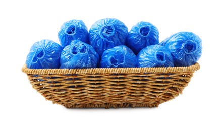 Rolled blue shoe covers in wicker basket isolated on white