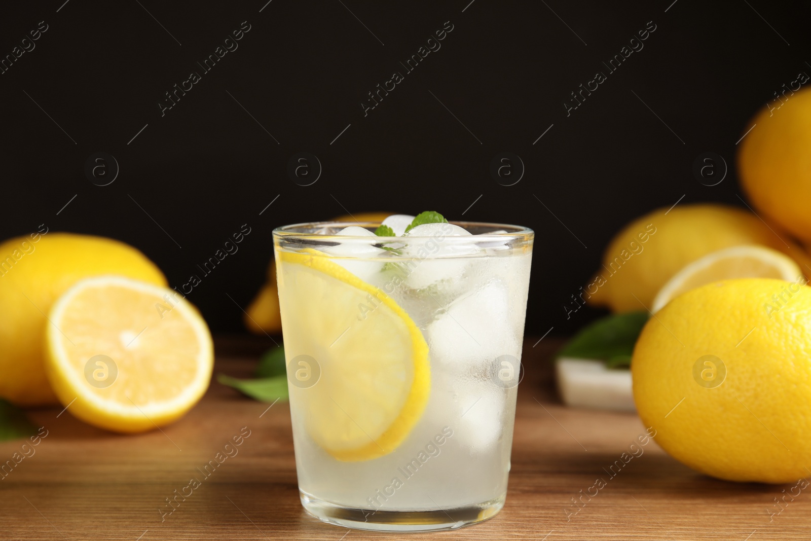 Photo of Cool freshly made lemonade and fruits on wooden table