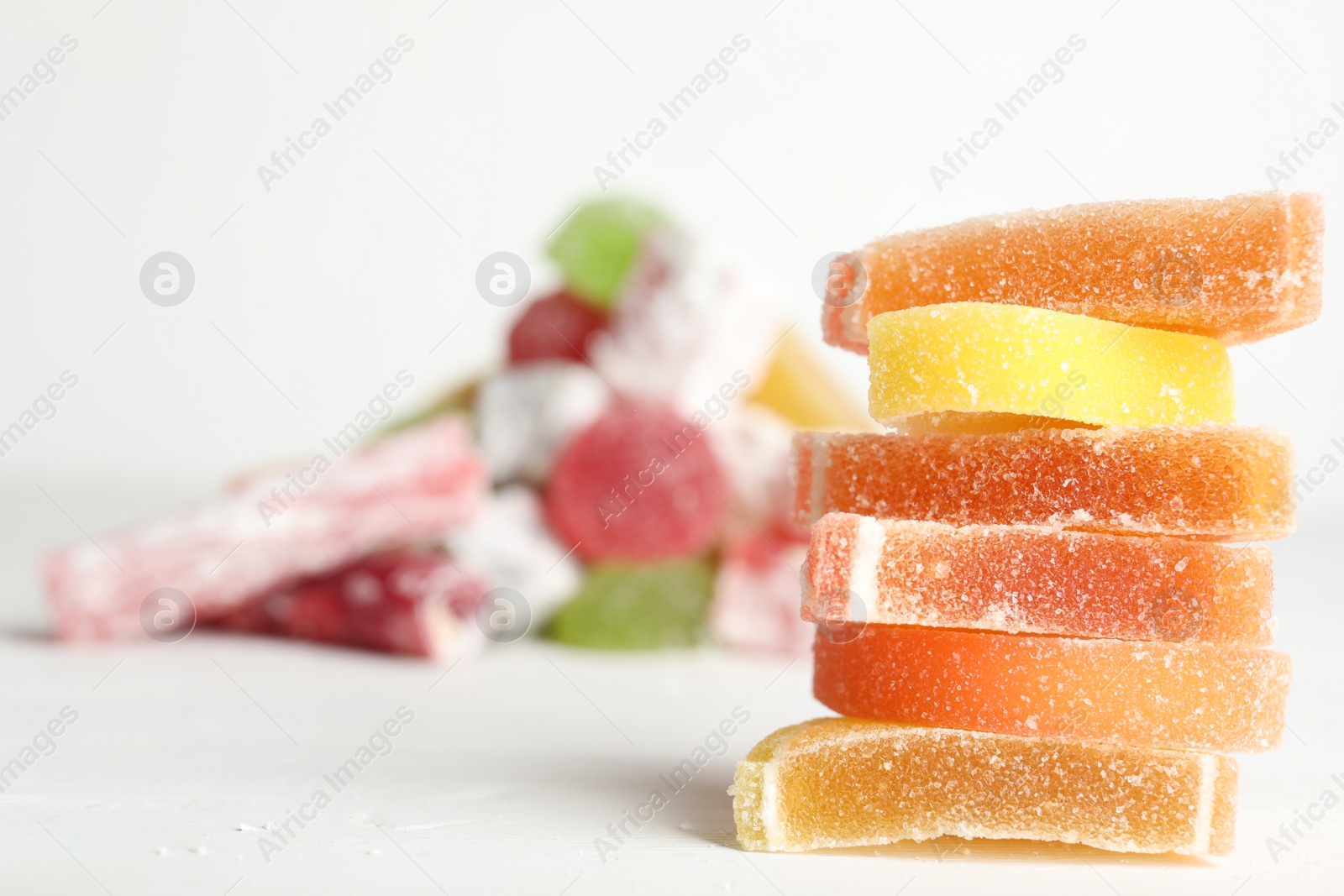 Photo of Delicious colorful candies on white table. Space for text